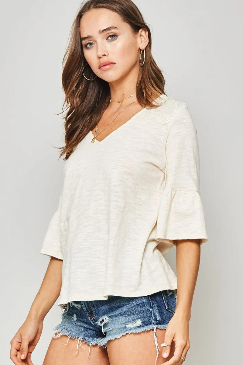 A Knit Top With Deep V Neckline And Yoke Design in Vanilla
